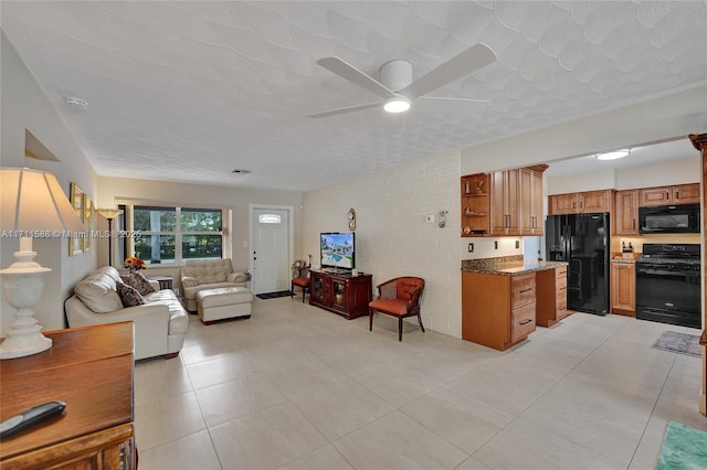 kitchen featuring black appliances, ceiling fan, dark stone countertops, and a textured ceiling