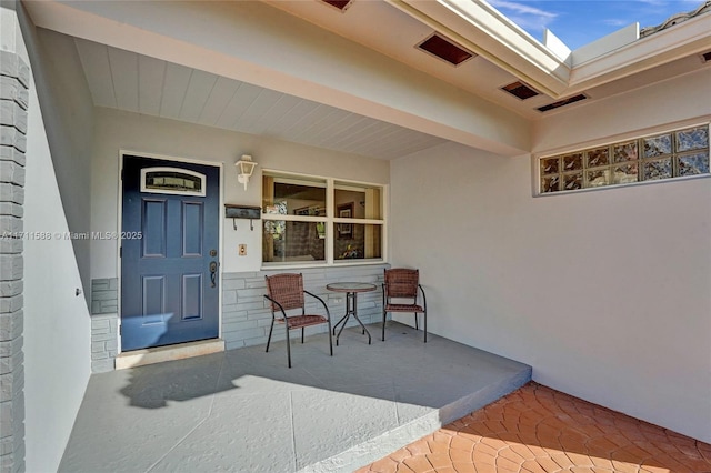 1407 Harding St, Hollywood, FL 33020 - view of exterior entry with stucco siding, visible vents, and a porch