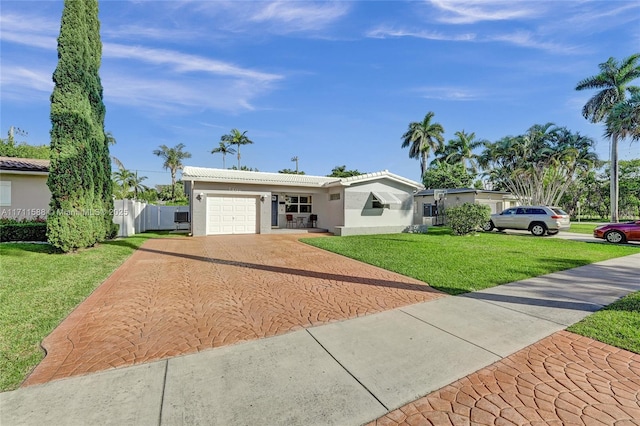 1407 Harding St, Hollywood, FL 33020 - ranch-style house with a front yard, stucco siding, fence, an attached garage, and decorative driveway