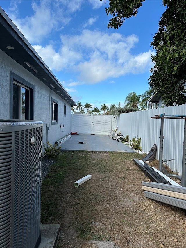 view of yard with central AC and a patio area