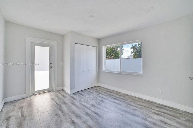 unfurnished bedroom featuring light wood-type flooring and a closet