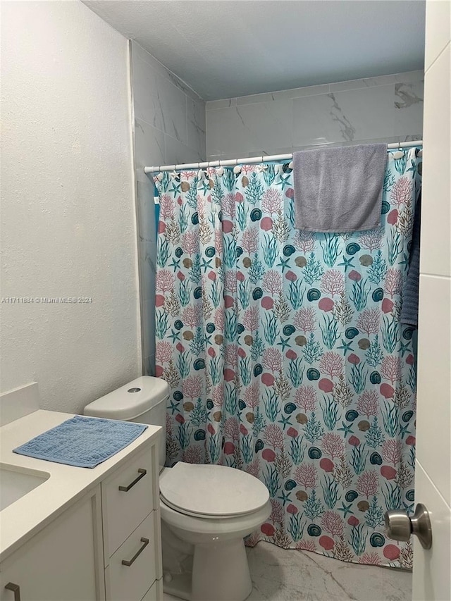 bathroom featuring vanity, curtained shower, and toilet