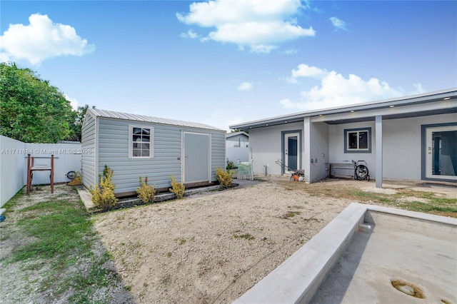 rear view of house featuring a storage shed