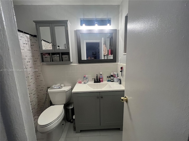 bathroom with toilet, tile walls, vanity, a shower with shower curtain, and tile patterned flooring