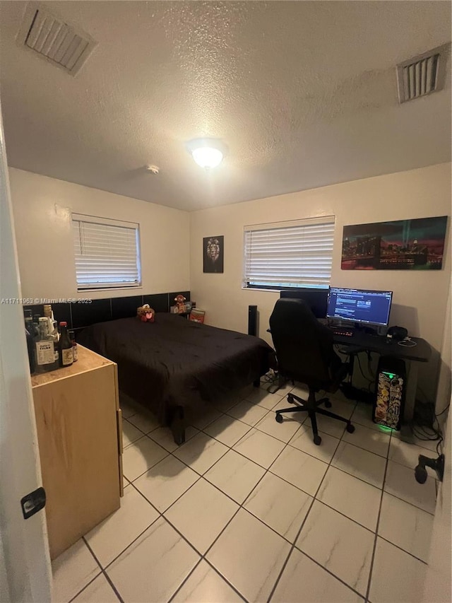 tiled bedroom with a textured ceiling