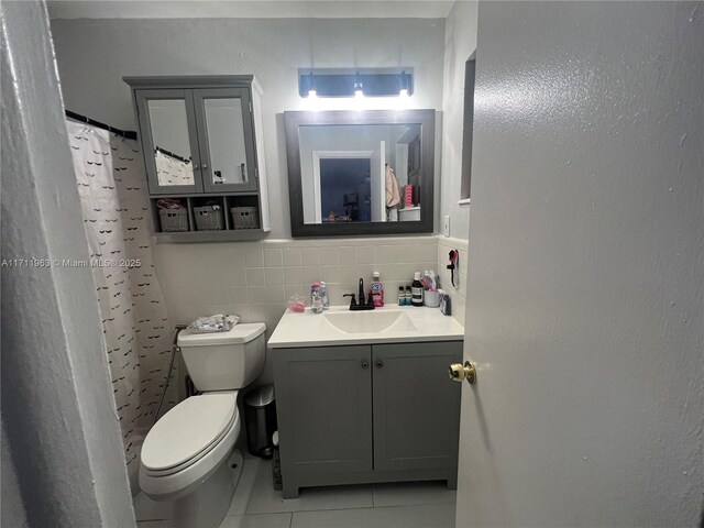 bathroom featuring vanity, backsplash, tile patterned floors, toilet, and tile walls