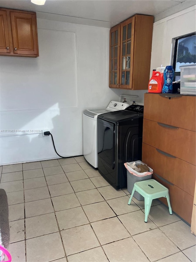 washroom featuring cabinets, separate washer and dryer, and light tile patterned floors