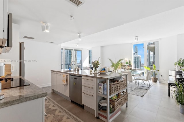 kitchen with a view of city, visible vents, stainless steel dishwasher, a sink, and black electric cooktop