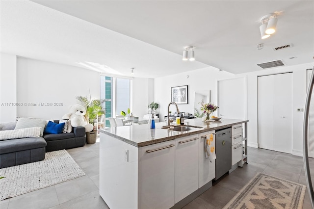 kitchen featuring a center island with sink, visible vents, open floor plan, stainless steel dishwasher, and a sink