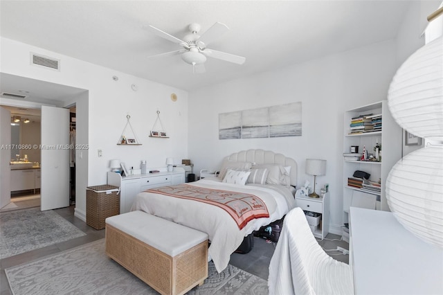 bedroom with ensuite bath, visible vents, and a ceiling fan