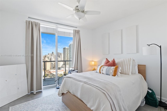 bedroom featuring access to exterior, a view of city, and a ceiling fan