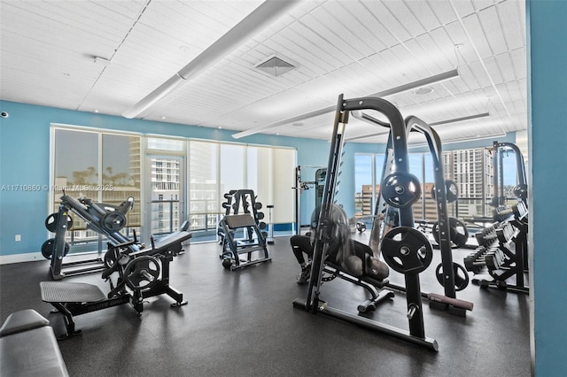 gym with a wealth of natural light, visible vents, and baseboards