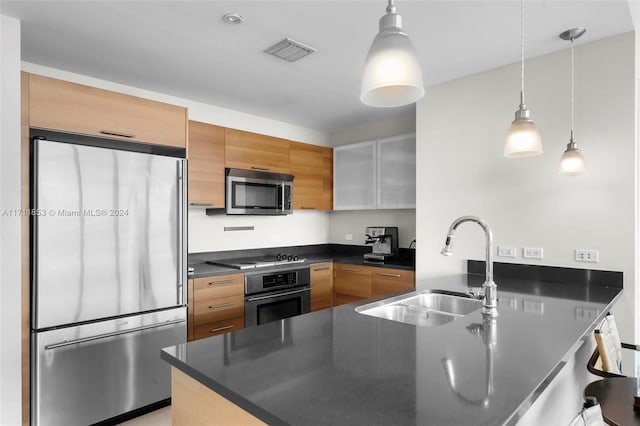 kitchen featuring white cabinets, decorative light fixtures, sink, and appliances with stainless steel finishes