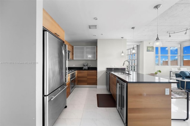 kitchen featuring sink, wine cooler, hanging light fixtures, kitchen peninsula, and stainless steel appliances