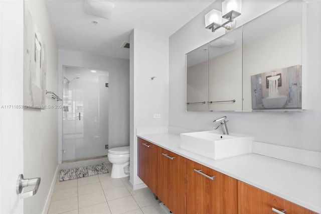 bathroom with tile patterned flooring, vanity, toilet, and a shower with shower door