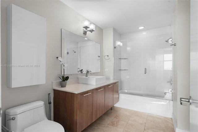 full bathroom with tile patterned flooring, vanity, bath / shower combo with glass door, and toilet