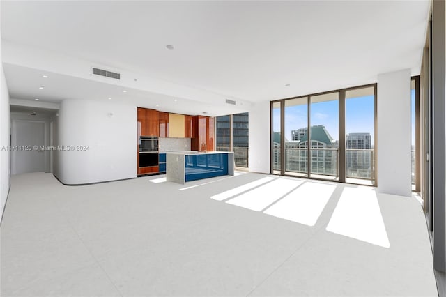 unfurnished living room featuring sink and a wall of windows