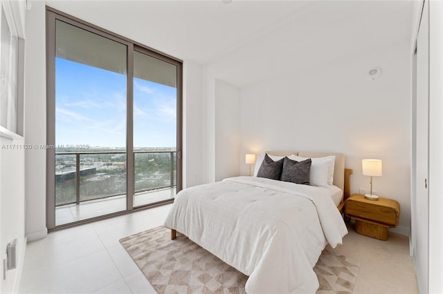 tiled bedroom featuring baseboards, access to outside, and expansive windows