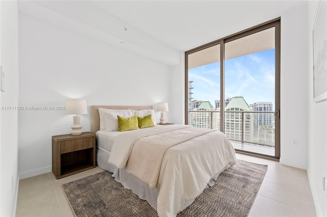 bedroom featuring access to outside, light tile patterned floors, baseboards, and a wall of windows