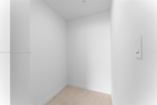 spare room featuring baseboards and light tile patterned flooring