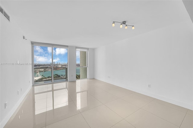 empty room with a water view and light tile patterned floors