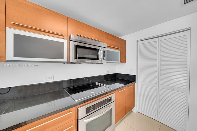 kitchen with light tile patterned floors and stainless steel appliances