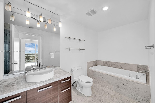 bathroom with vanity, toilet, and tiled bath