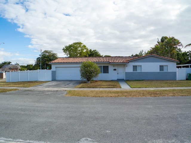 single story home featuring a front lawn and a garage