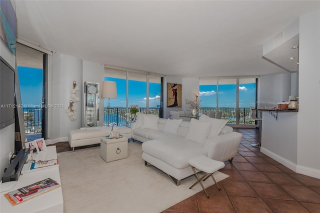 living room featuring tile patterned flooring, a wall of windows, and a wealth of natural light