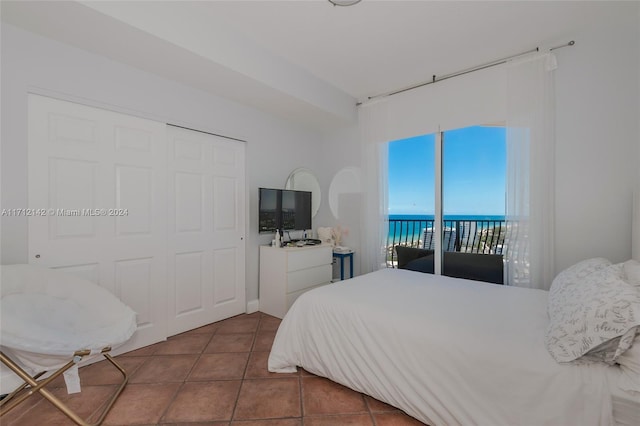 bedroom featuring tile patterned flooring, access to exterior, and a closet