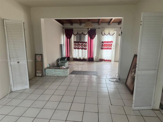 interior space with beam ceiling and light tile patterned flooring