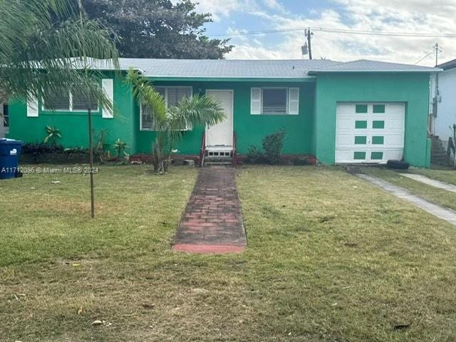 view of front of house with a garage and a front lawn