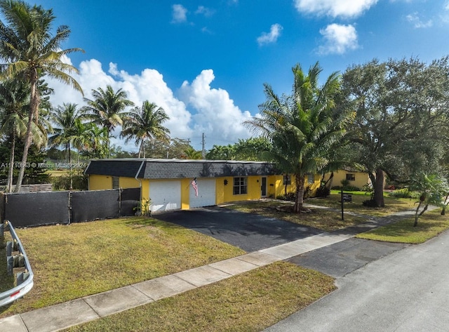 view of front of house featuring a garage and a front lawn