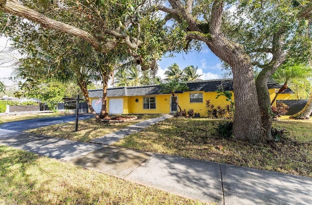 ranch-style home with a front yard and a garage