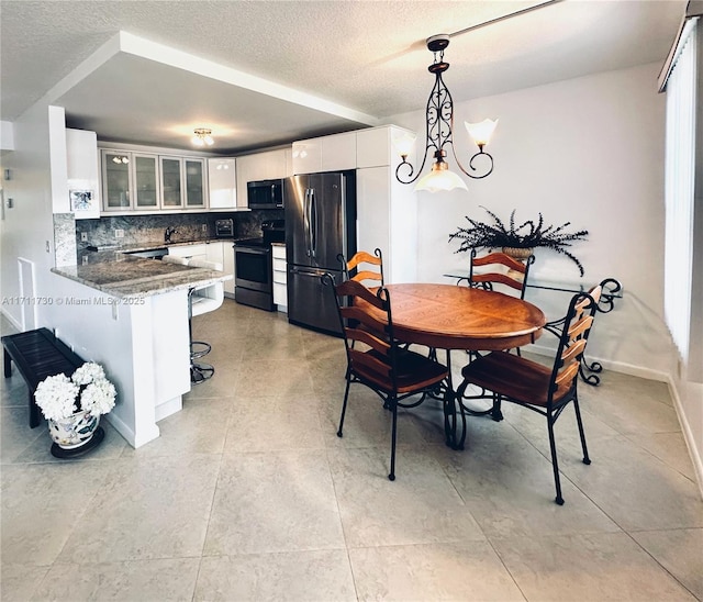 dining space with a textured ceiling and baseboards