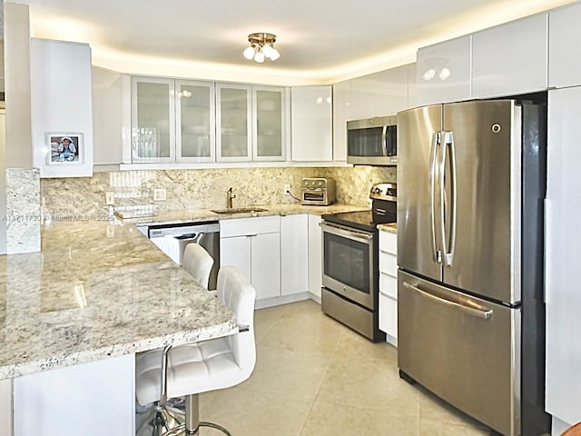 1016 Newcastle A 1016, Boca Raton, FL 33434 - kitchen with appliances with stainless steel finishes, modern cabinets, light stone countertops, and white cabinetry