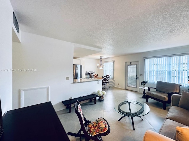 living area with visible vents, plenty of natural light, and a textured ceiling