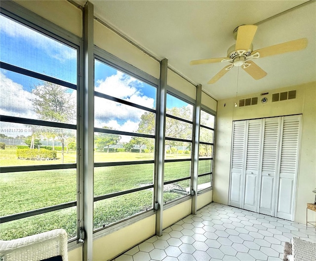 unfurnished sunroom featuring ceiling fan