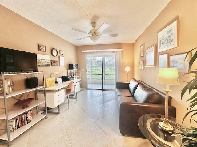 tiled living room featuring ceiling fan and a textured ceiling