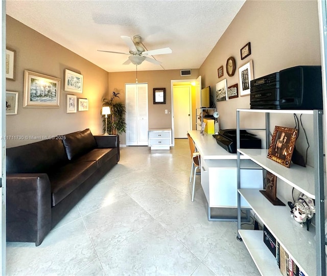 living room with a textured ceiling and ceiling fan