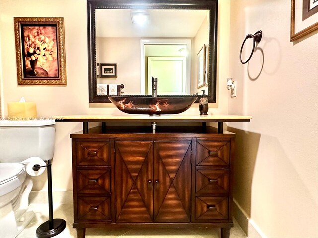 bathroom with tile patterned flooring, vanity, and toilet