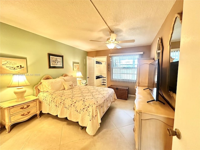 tiled bedroom with ceiling fan and a textured ceiling