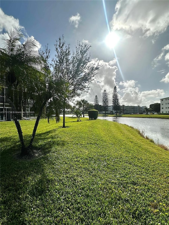 view of property's community with a water view and a yard