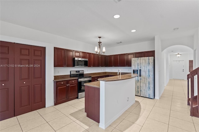 kitchen featuring hanging light fixtures, an island with sink, stone countertops, light tile patterned flooring, and appliances with stainless steel finishes