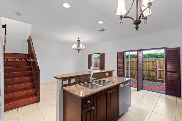 kitchen with light stone counters, a kitchen island with sink, sink, dishwasher, and hanging light fixtures