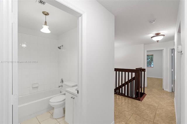 full bathroom featuring tile patterned floors, tiled shower / bath, vanity, and toilet