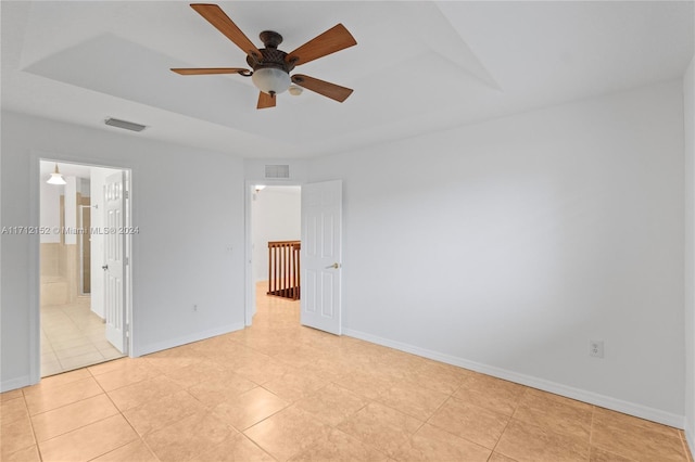 unfurnished bedroom with ensuite bathroom, ceiling fan, and light tile patterned flooring