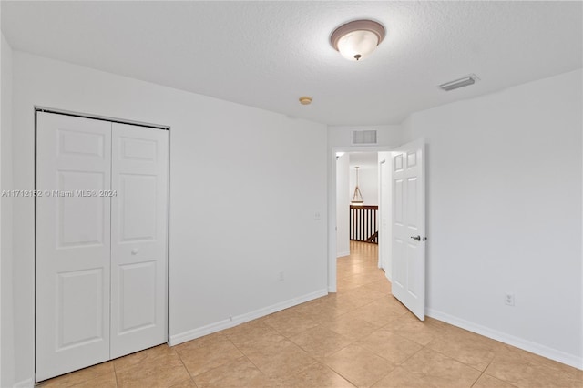 unfurnished bedroom with a textured ceiling and a closet