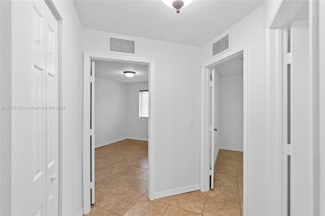 corridor with light tile patterned floors