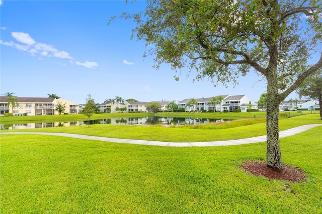 view of home's community with a lawn and a water view